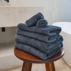 Ritual Bath Sheet Set by Rest & Reset styled on a wooden bench, emphasizing durability and relaxed luxury