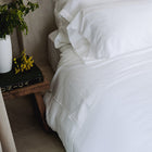 Murmur Pillow Sham by Rest & Reset styled in soft lighting, enhancing warmth and comfort in the bedroom