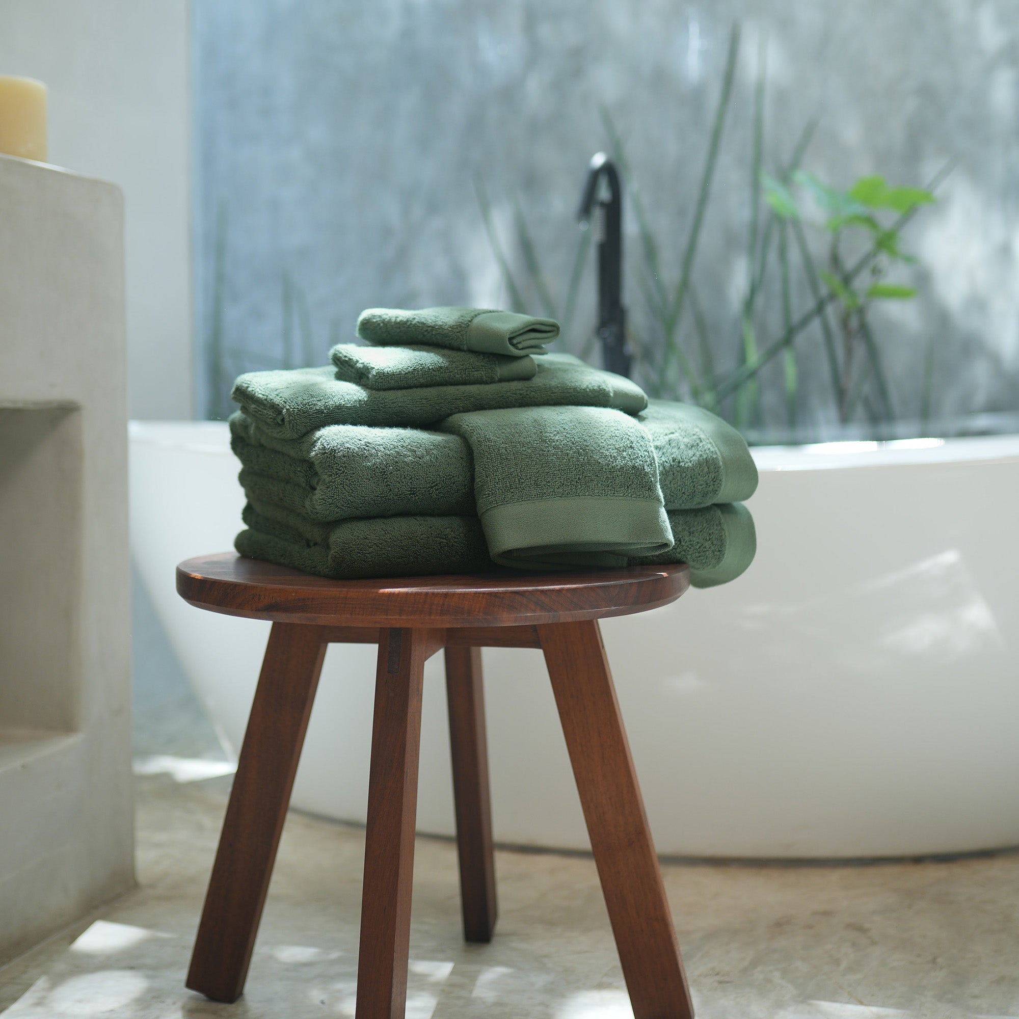 Oasis Bath Sheet Set by Rest & Reset styled on a wooden stool, combining functionality with spa-inspired comfort
