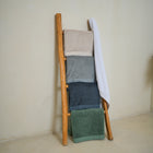 Oasis Bath Towels Pair by Rest & Reset styled on a wooden bench, enhancing a warm and serene bathroom aesthetic 