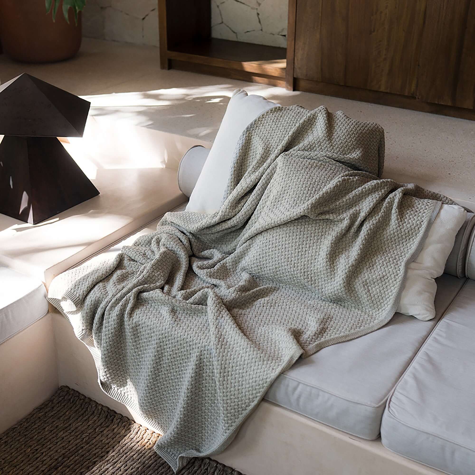 Pause Throw Blanket by Rest & Reset styled on a bed during rest, creating a relaxed and soothing atmosphere