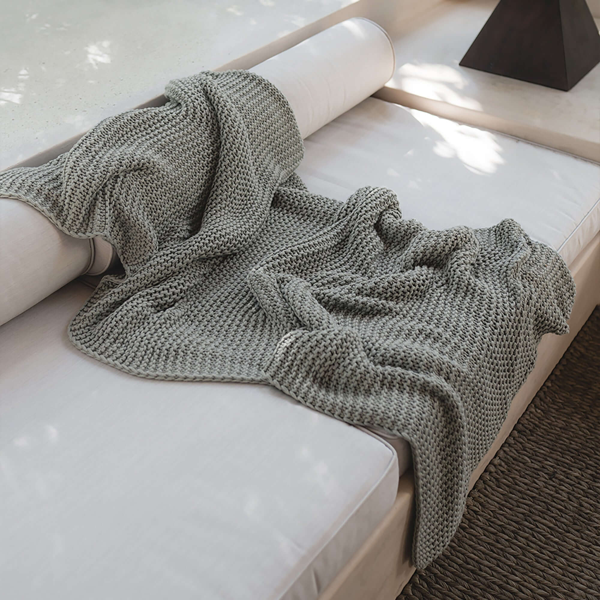 Whisper Throw Blanket by Rest & Reset draped over bedding, designed for cozy moments and mindful living