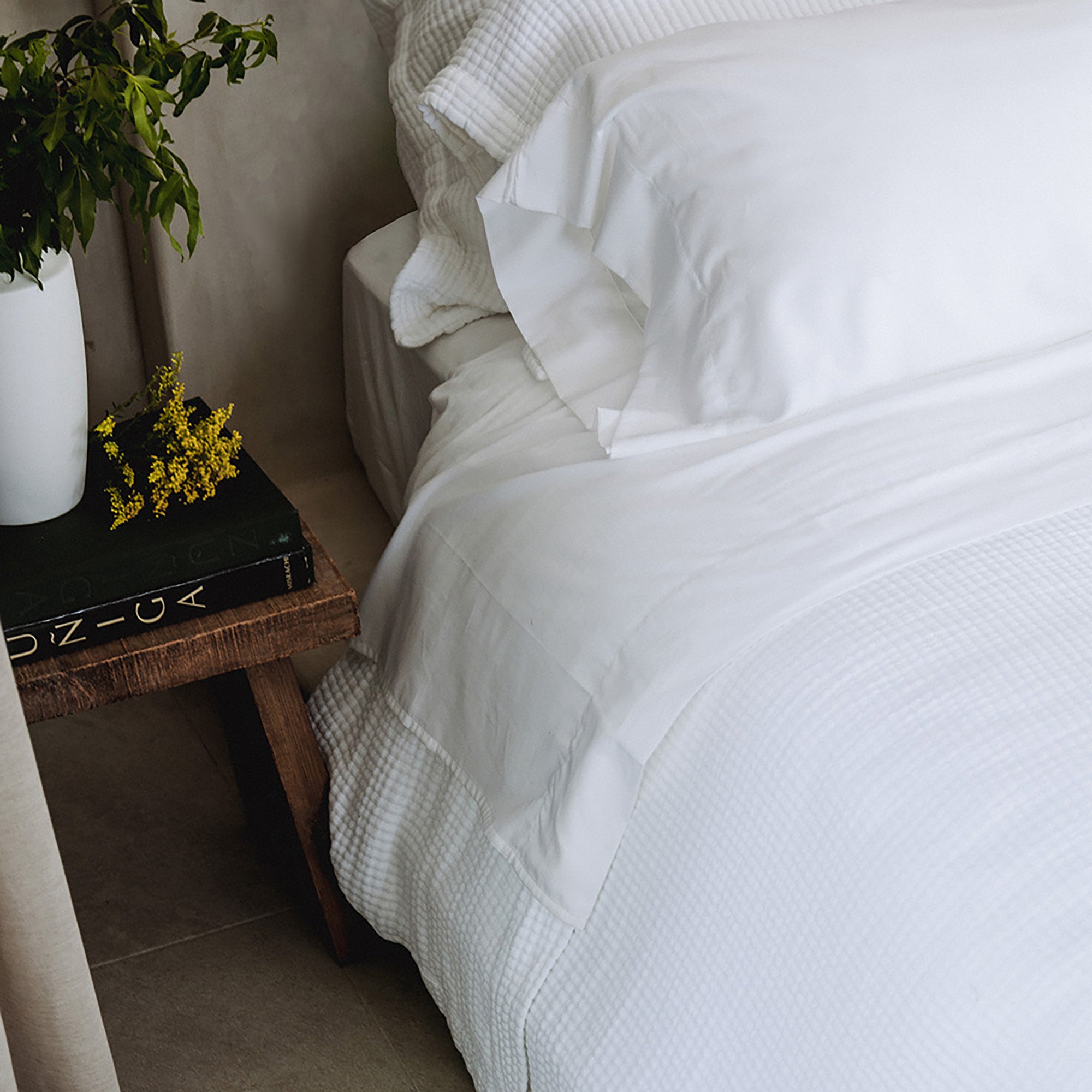 Murmur Pillow Sham by Rest & Reset styled in soft lighting, enhancing warmth and comfort in the bedroom