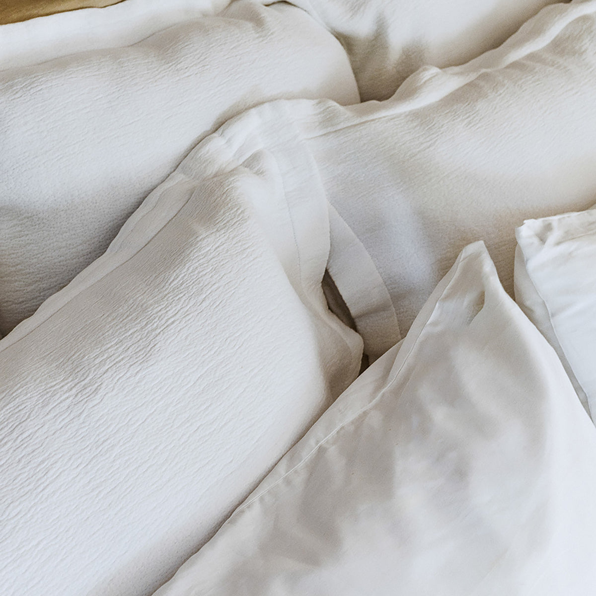 Close-up of organic cotton fabric on Waves Euro Sham by Rest & Reset in use, showing natural drape and softness