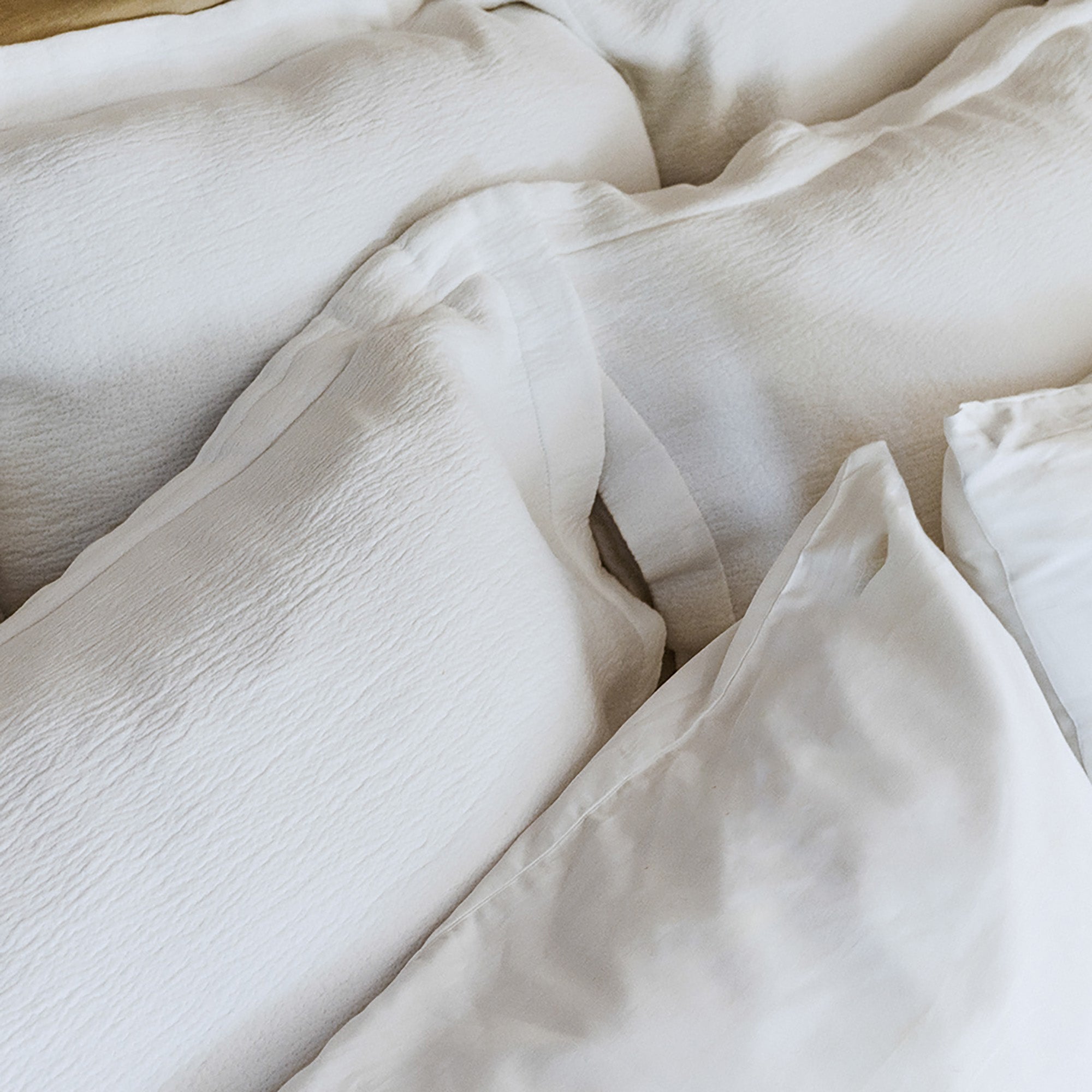 Close-up of organic cotton fabric on Waves Euro Sham by Rest & Reset in use, showing natural drape and softness