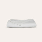 Waves Quilt styled with pillows in refined organic cotton luxury bedding by Rest & Reset