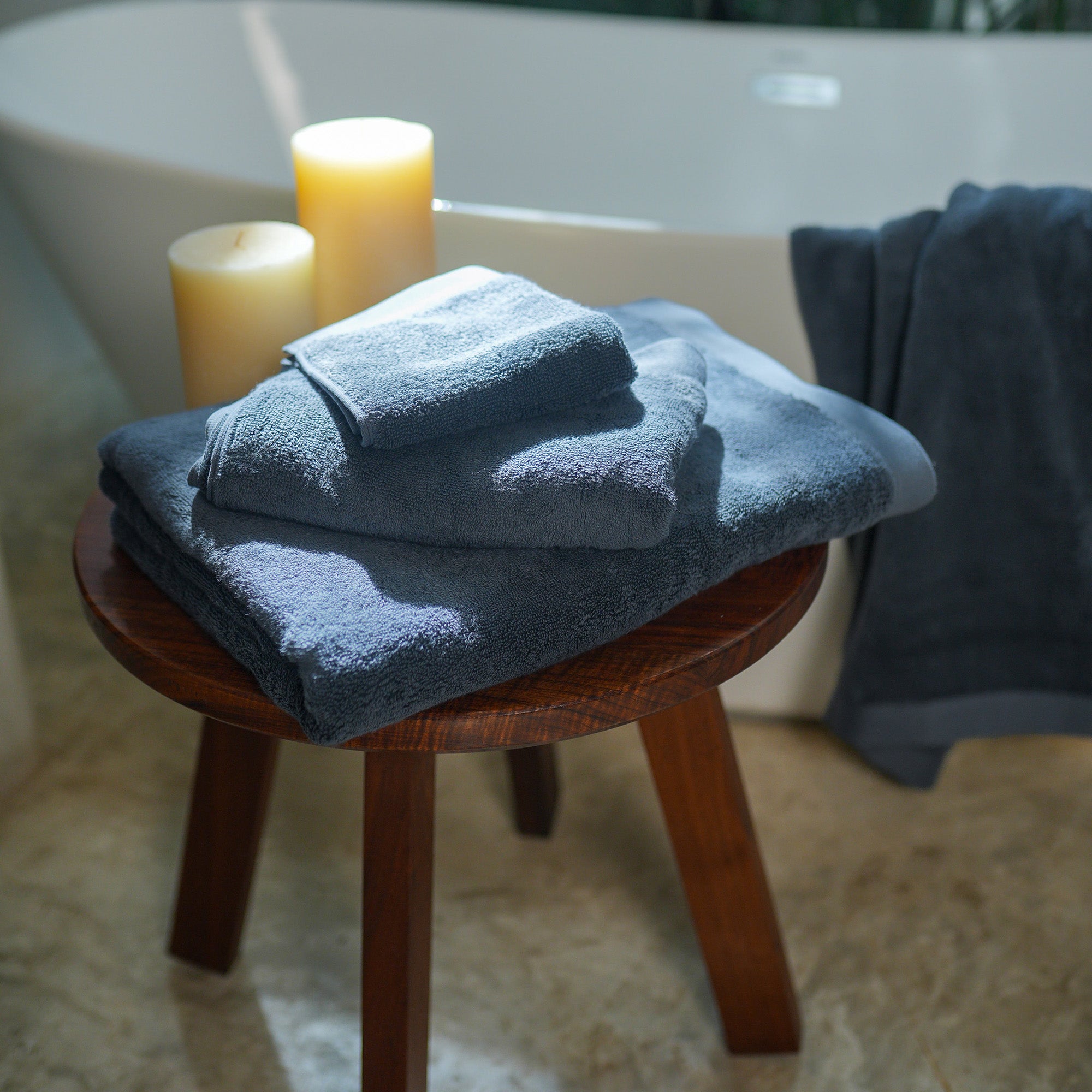 Oasis Washcloths Pair by Rest & Reset styled on a wooden stool, combining relaxed luxury with everyday utility