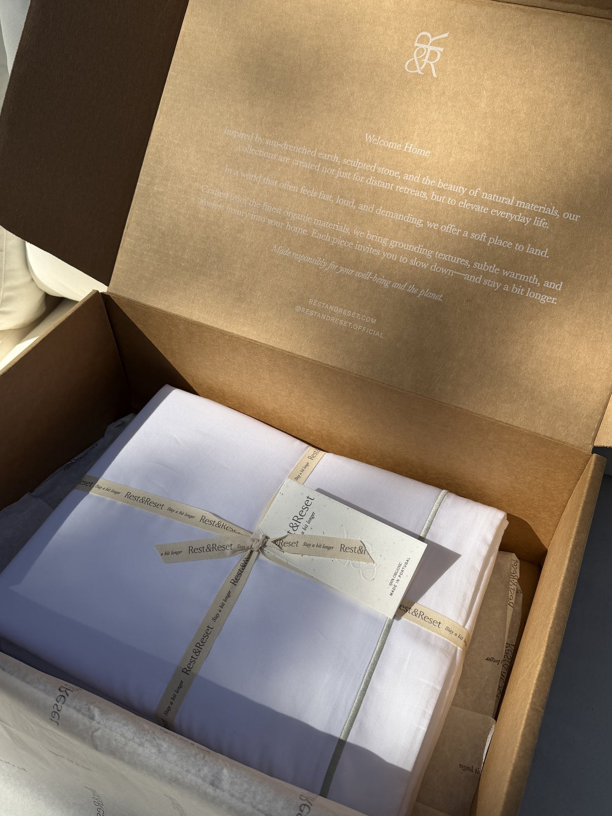 Rest & Reset bedding tied with signature ribbon inside the gift box